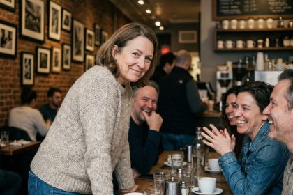 Femme souriante en café avec amis en intérieur