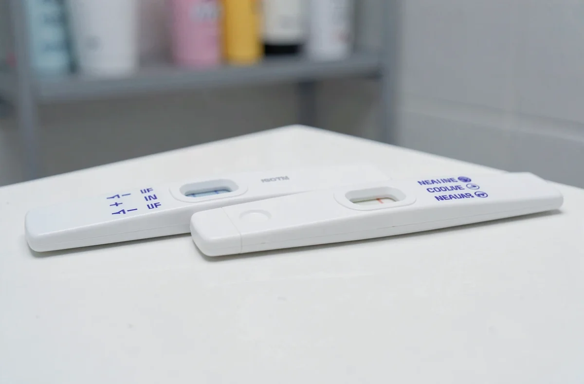 Gros plan de deux tests de grossesse côte à côte montrant une barre d'évaporation et un résultat négatif pour comparaison